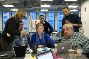 Gender parity in the workplace. A group of men and women around a table doing Scrum.