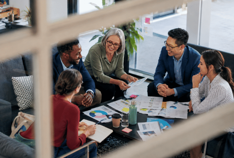 Professionals collaborating around a table during a Scrum Master training session